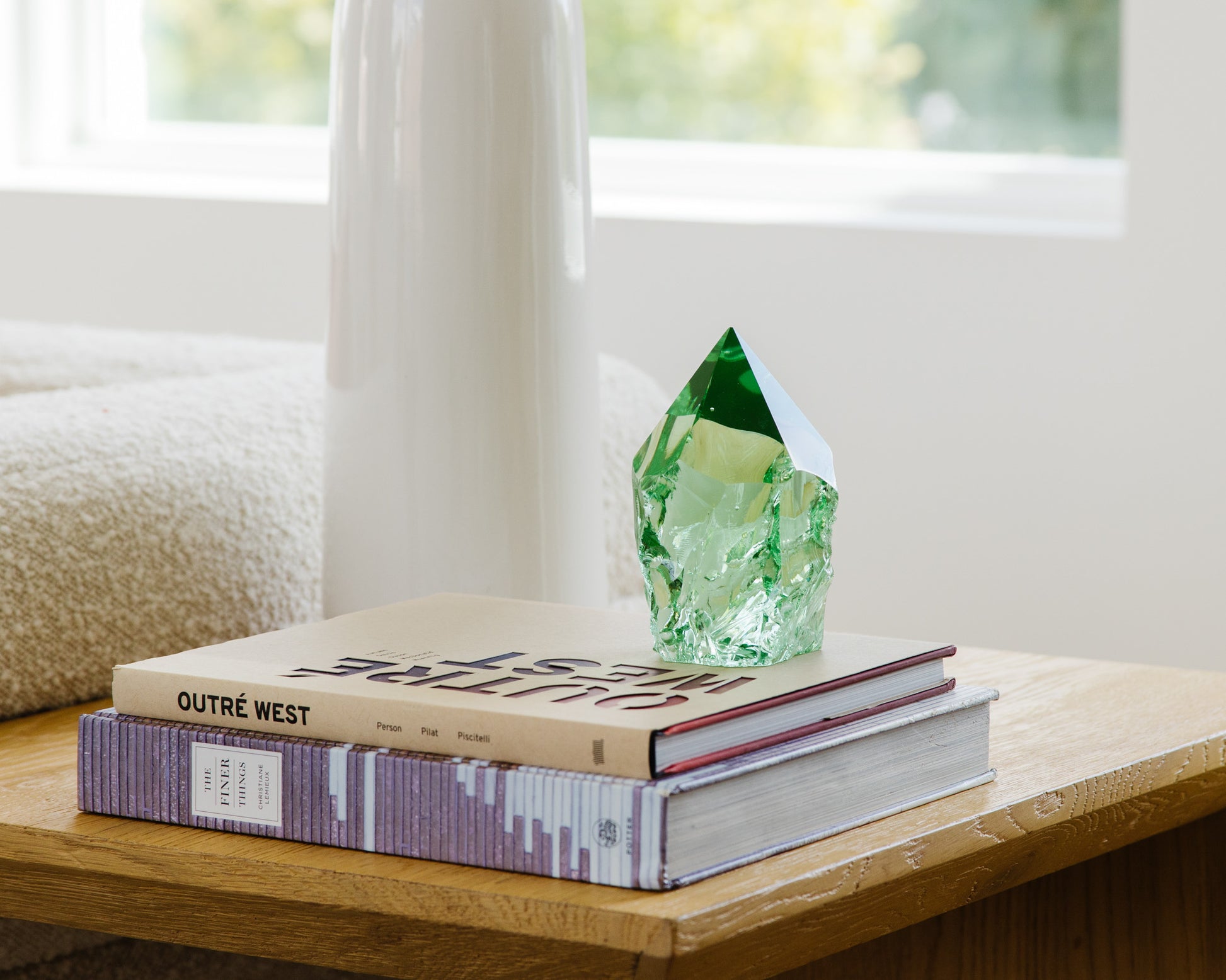 Green glass decorative point styled with books on a rustic wood accent table