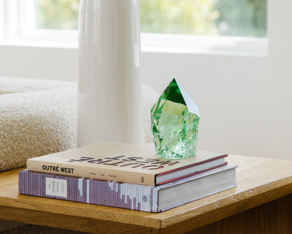 Green glass decorative point styled with books on a rustic wood accent table