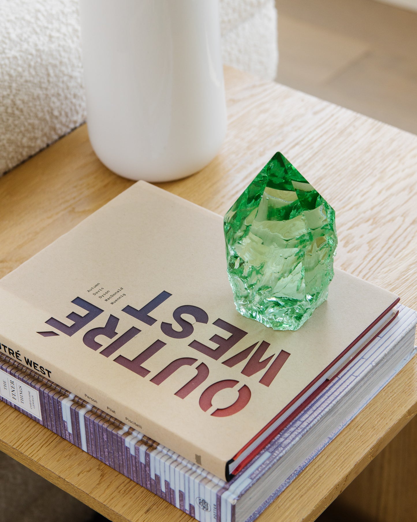 Decorative rustic green glass point with white vase and stacked books