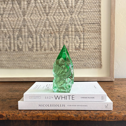 Rustic green glass crystal point styled on neutral decor books