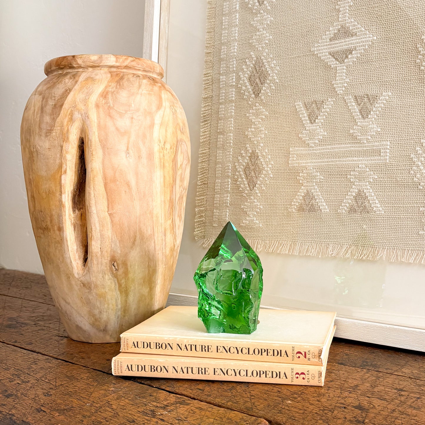 Green glass crystal point centerpiece on book stack with rustic wood vase