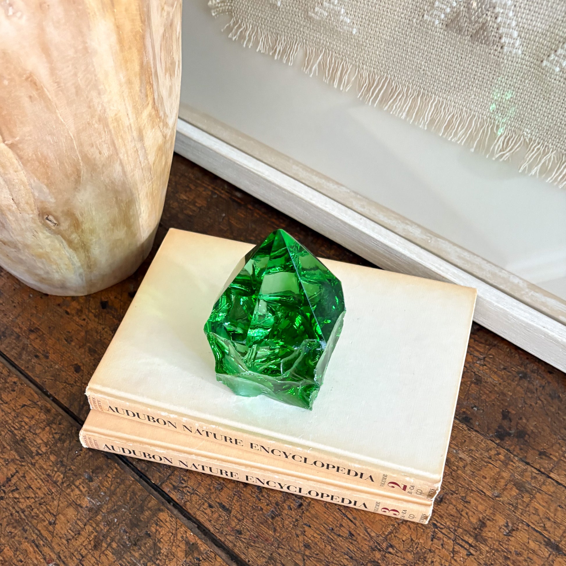 Green glass point tower decor styled with natural wood vase and woven textile