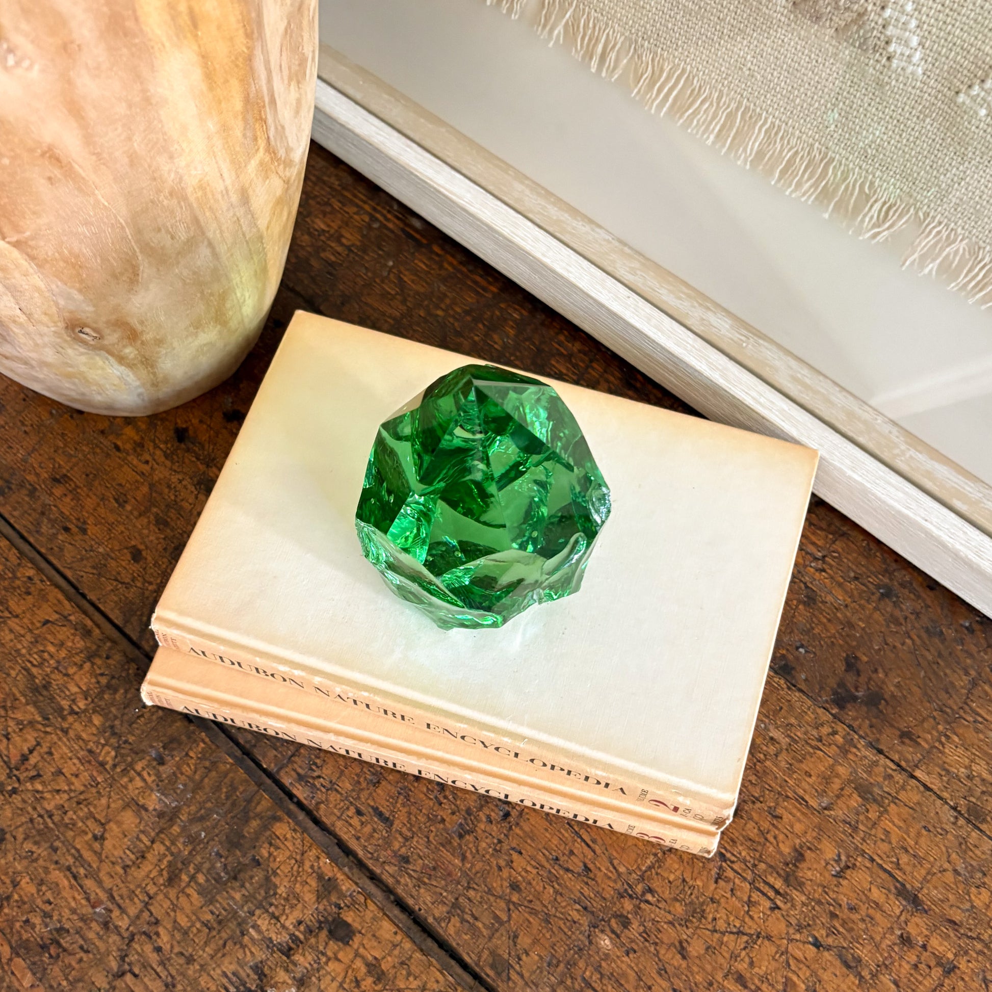 Green glass point tower decor styled with natural wood vase and woven textile