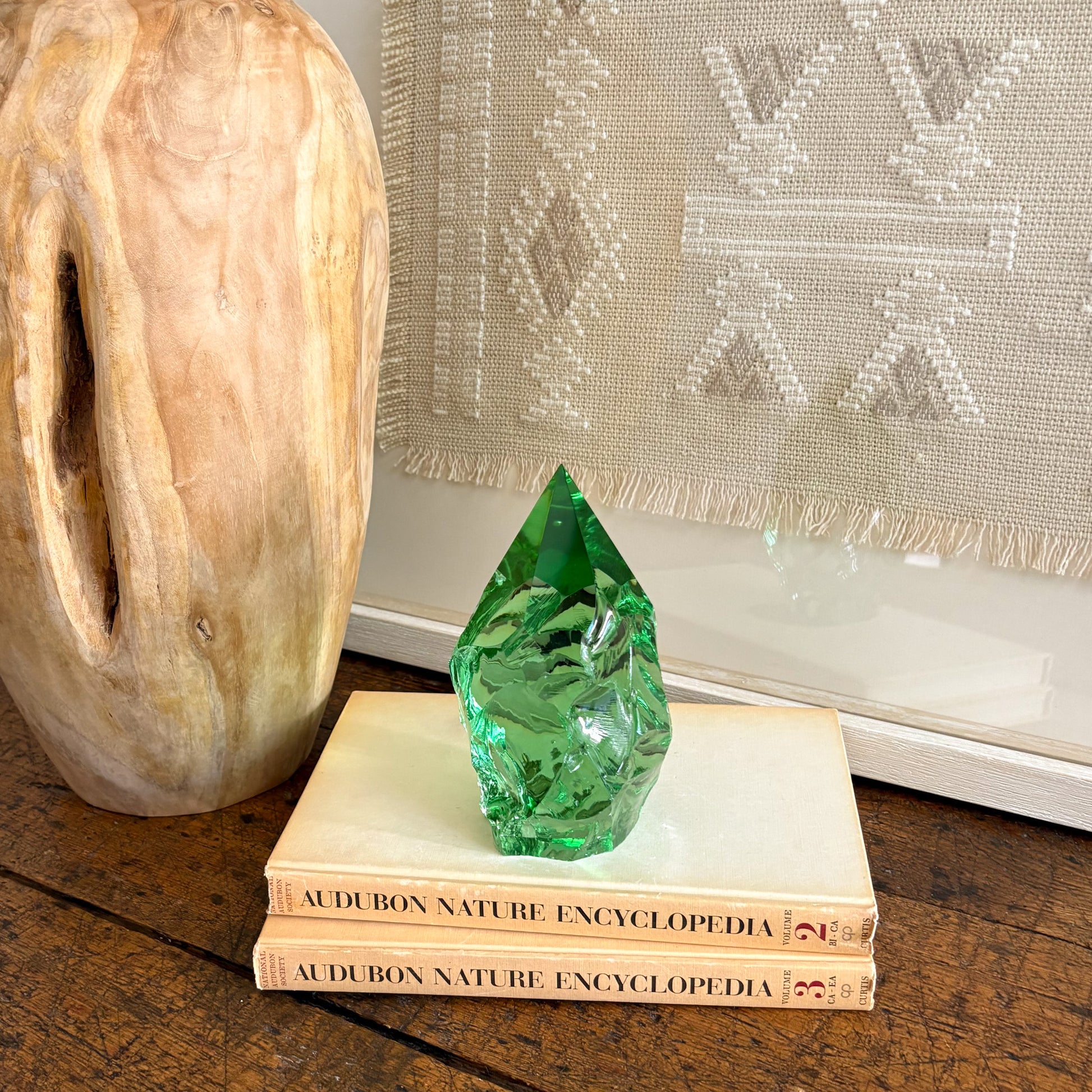 Green glass crystal point centerpiece on book stack with rustic wood vase