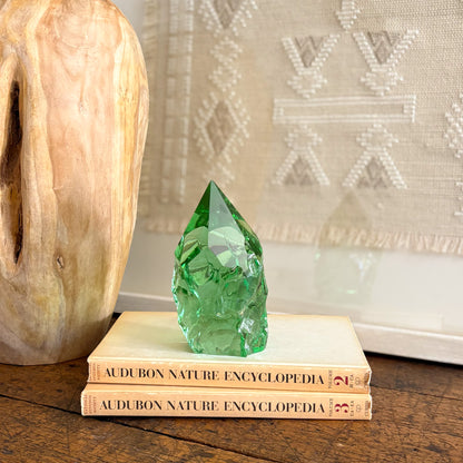 Rustic green glass point tower styled on vintage books on wooden table