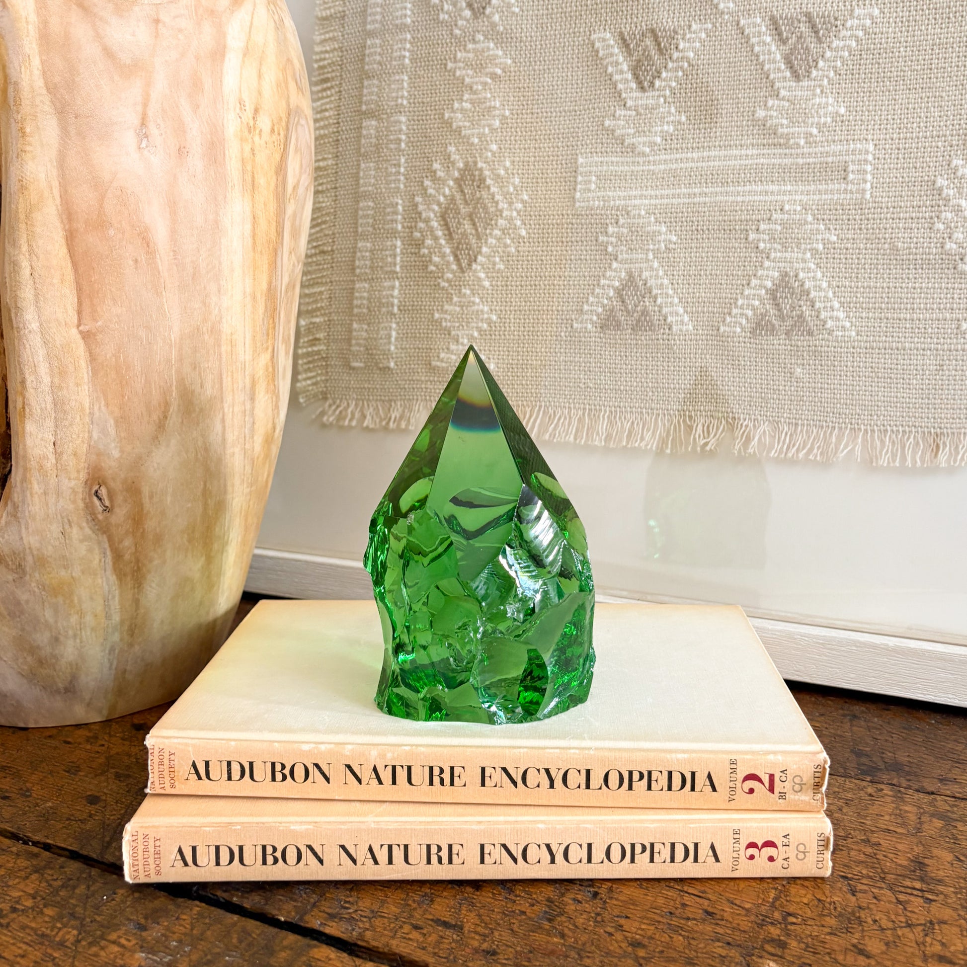 Rustic green glass point tower styled on vintage books on wooden table