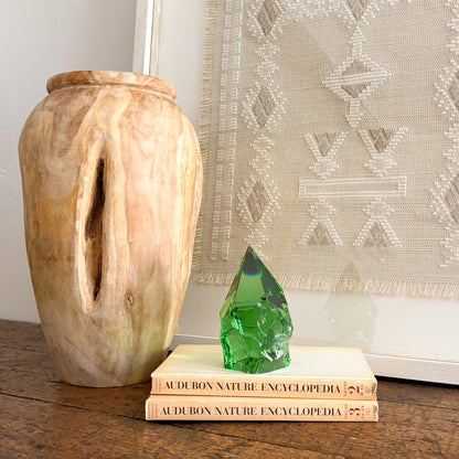 Green glass point tower decor styled with natural wood vase and woven textile