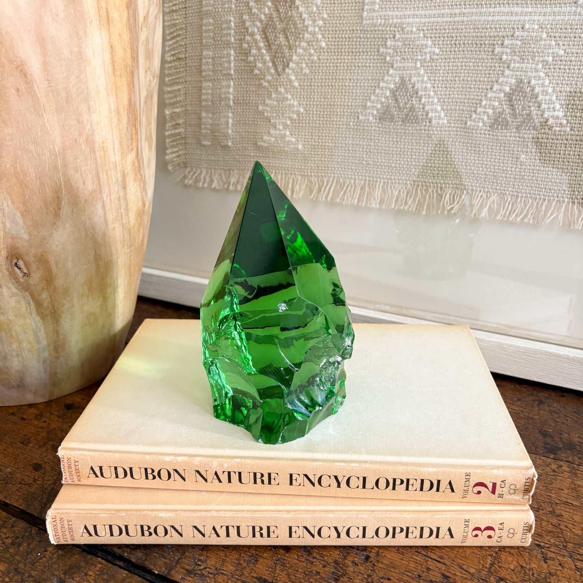 Rustic green glass point displayed on vintage Audubon Nature Encyclopedia books