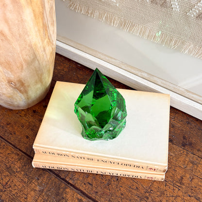 Rustic green glass obelisk point styled on books in boho neutral decor setting