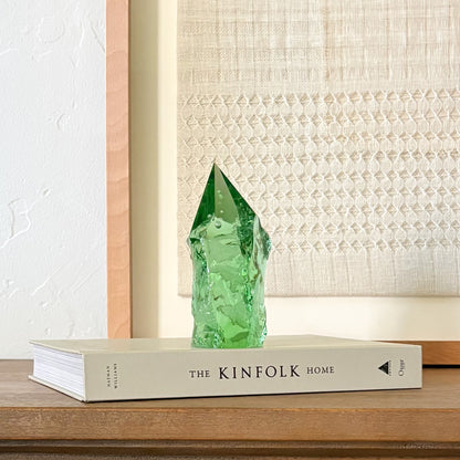 Rustic green glass tower decor on Kinfolk book, soft neutral aesthetic background