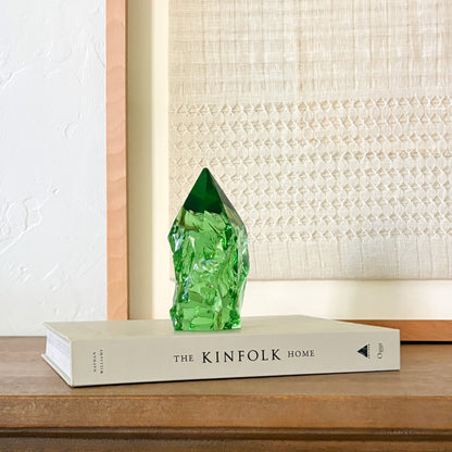 Green glass crystal point centerpiece with organic texture, styled on book in neutral home setting
