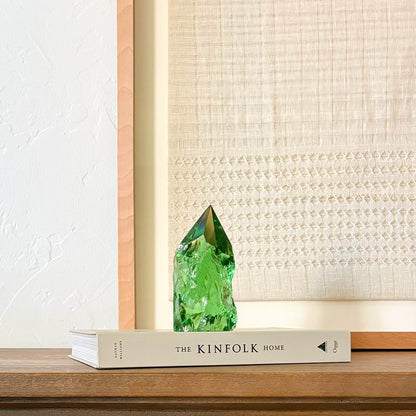 Rustic green glass tower decor on Kinfolk book, soft neutral aesthetic background