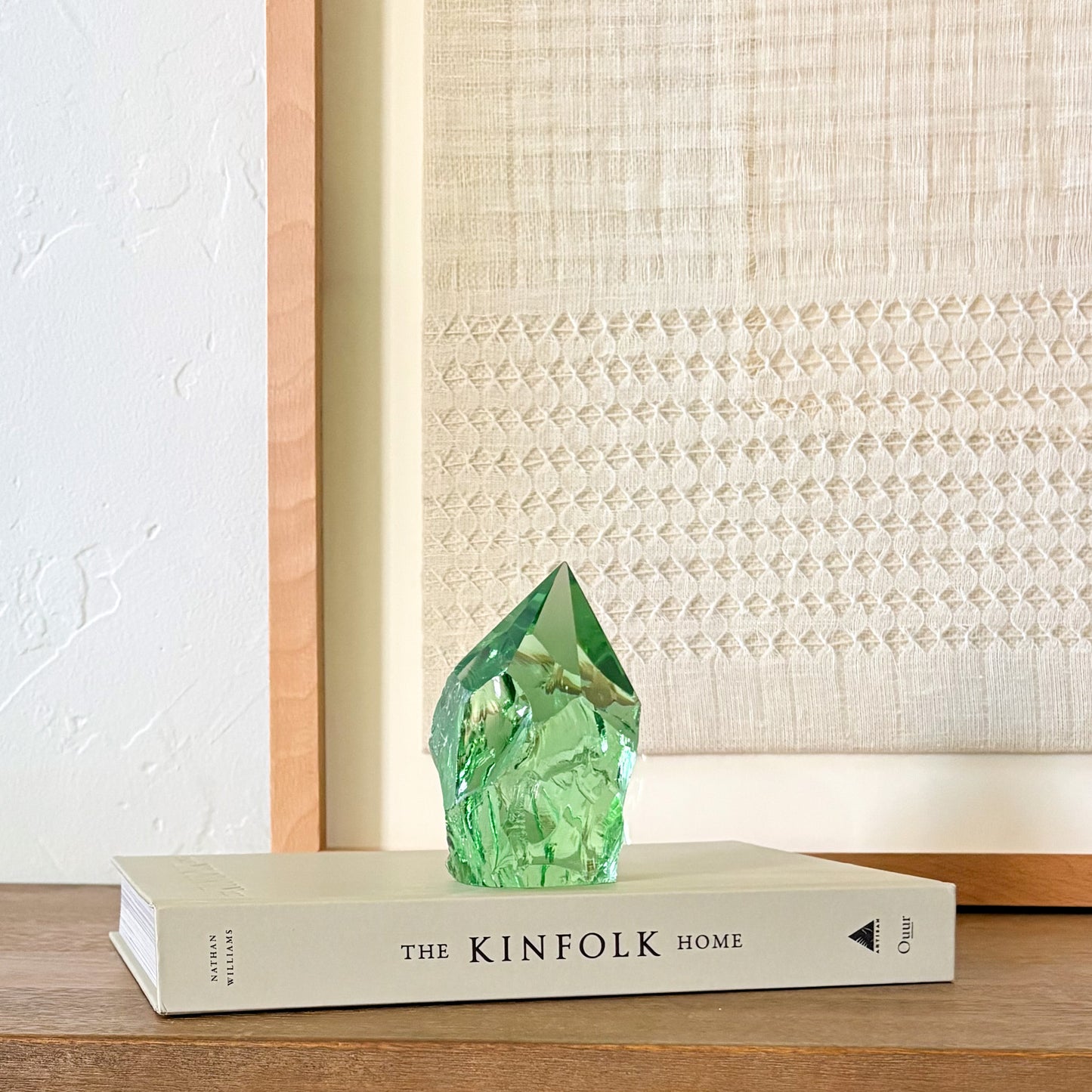 Rustic green glass tower decor on Kinfolk book, soft neutral aesthetic background