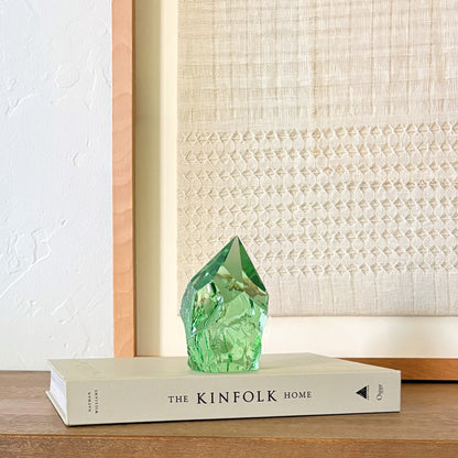 Rustic green glass tower decor on Kinfolk book, soft neutral aesthetic background