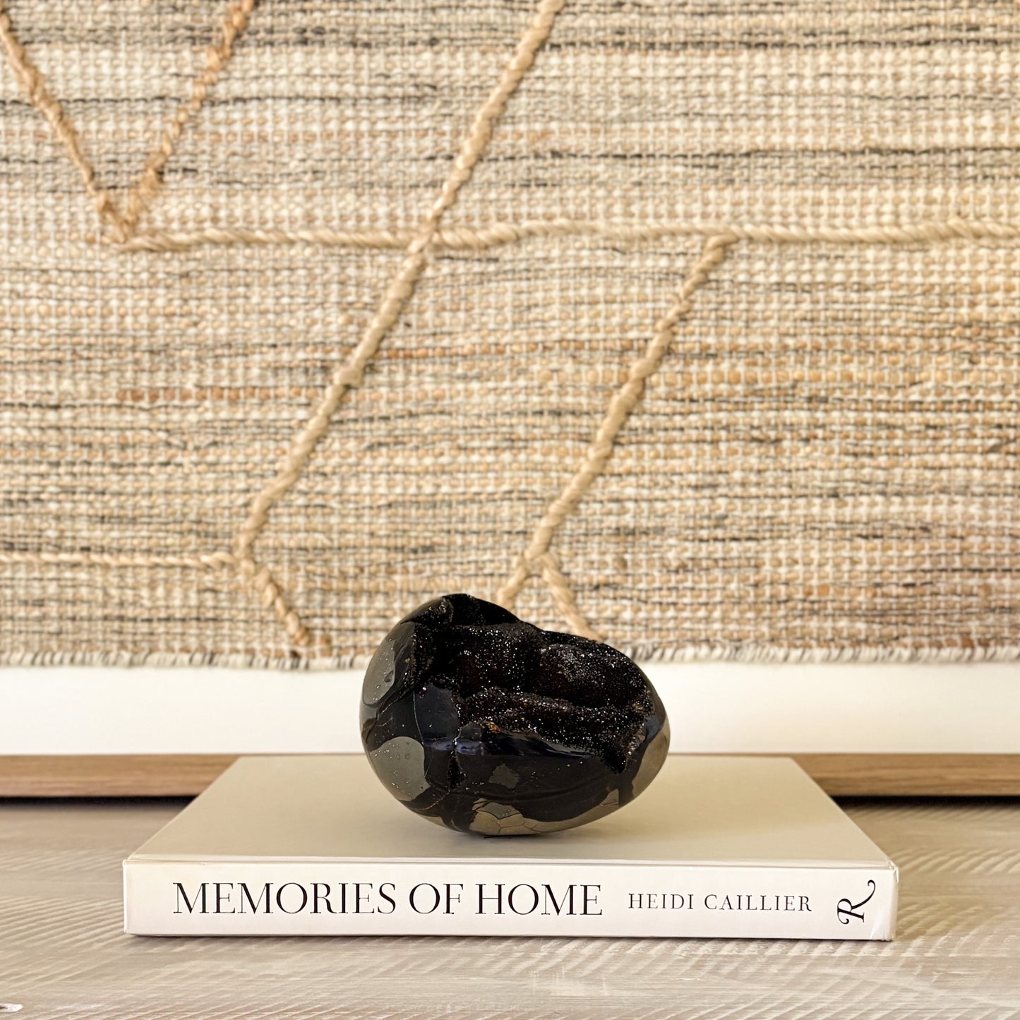 Decorative black crystal stone on a book titled 'Memories of Home' with a textured wall background
