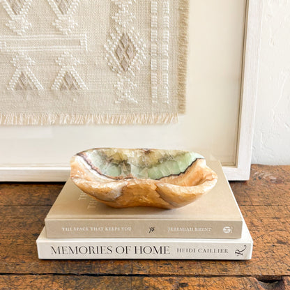 Luxury natural stone bowl with translucent green onyx tones on a neutral interior surface