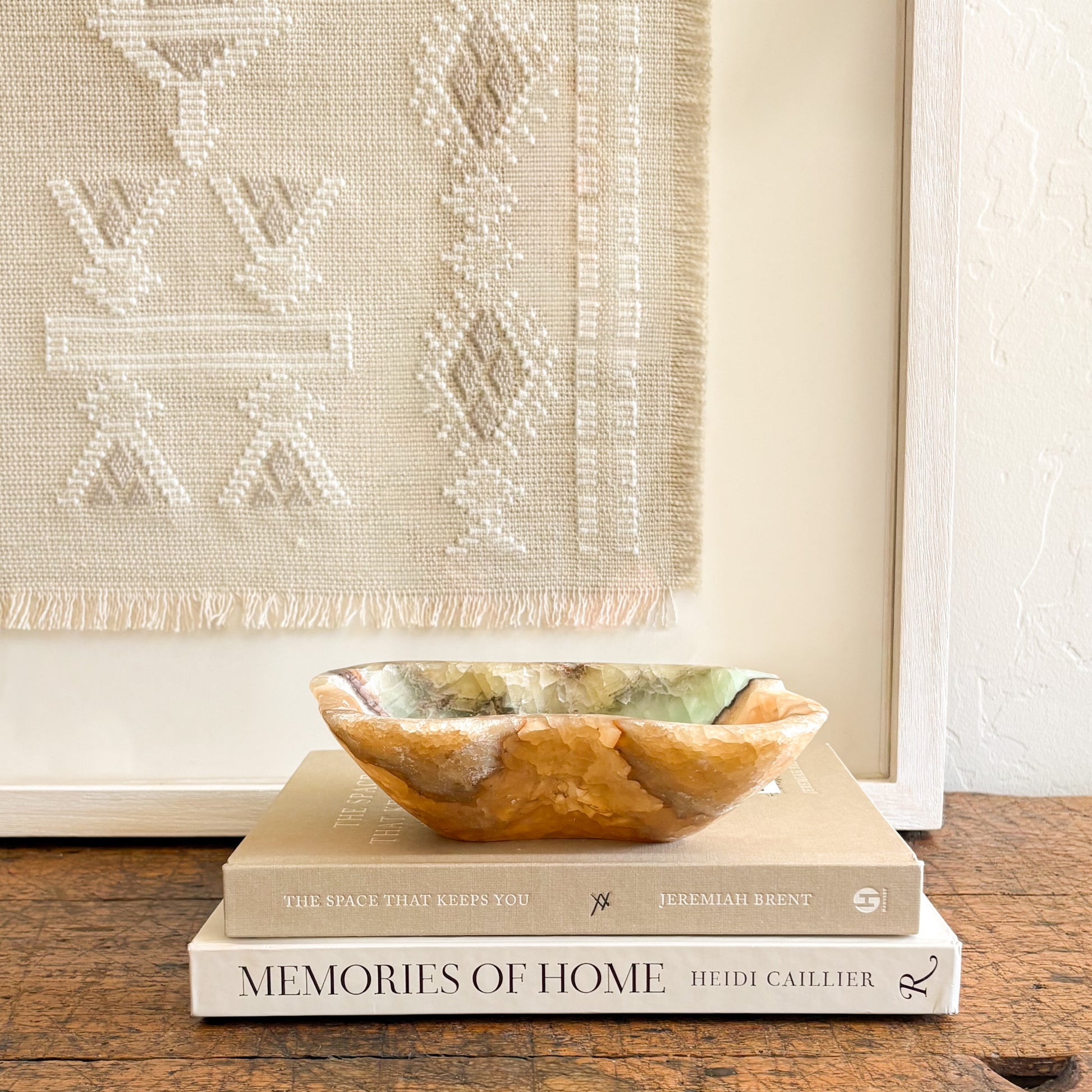 Minimalist home decor styling featuring a sculptural serpentine onyx bowl