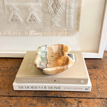 Small serpentine onyx bowl styled as a luxury jewelry dish on a bedside table