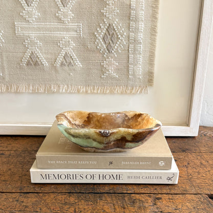 Hand-polished serpentine onyx bowl showcasing organic stone layers and sculptural form