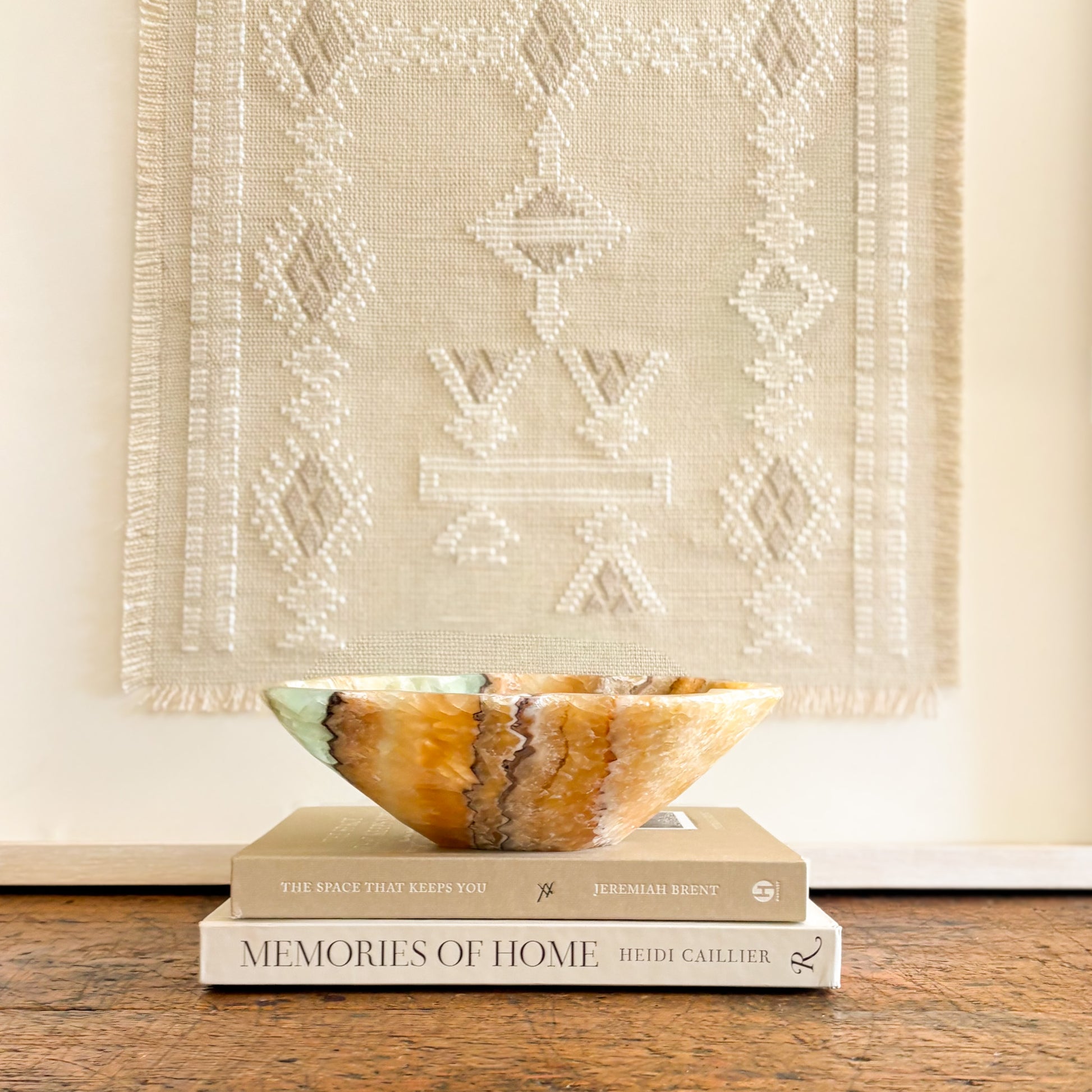 Handcrafted serpentine onyx bowl with green and amber tones displayed as elegant home decor