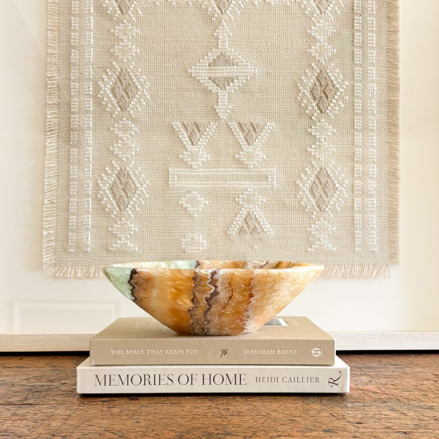 Serpentine onyx decorative bowl with green and honey stone veining styled on coffee table books as home decor