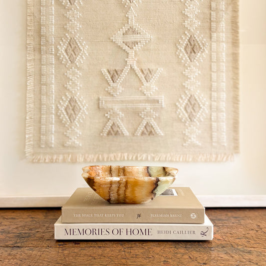 Small serpentine onyx bowl with natural green and honey stone veining styled as luxury home decor