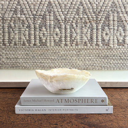 Decorative bowl on books with a textured wall in the background