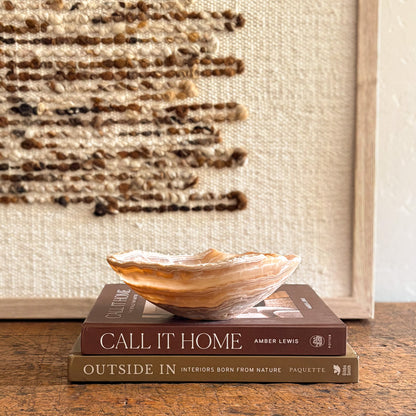 Amber onyx bowl on stacked design books.