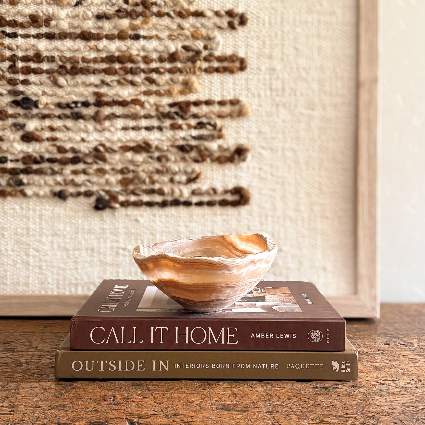 Artisan amber onyx bowl showcasing layered stone patterns, styled in a warm neutral interior vignette