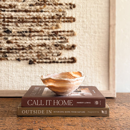 Artisan amber onyx bowl showcasing layered stone patterns, styled in a warm neutral interior vignette