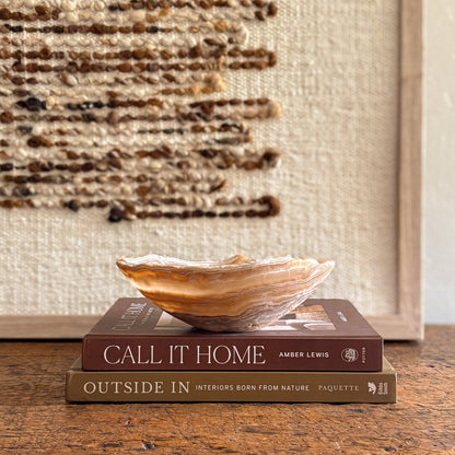 Hand-carved amber onyx bowl styled on books.