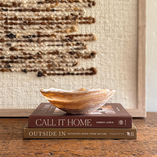Hand-carved amber onyx bowl styled on books.
