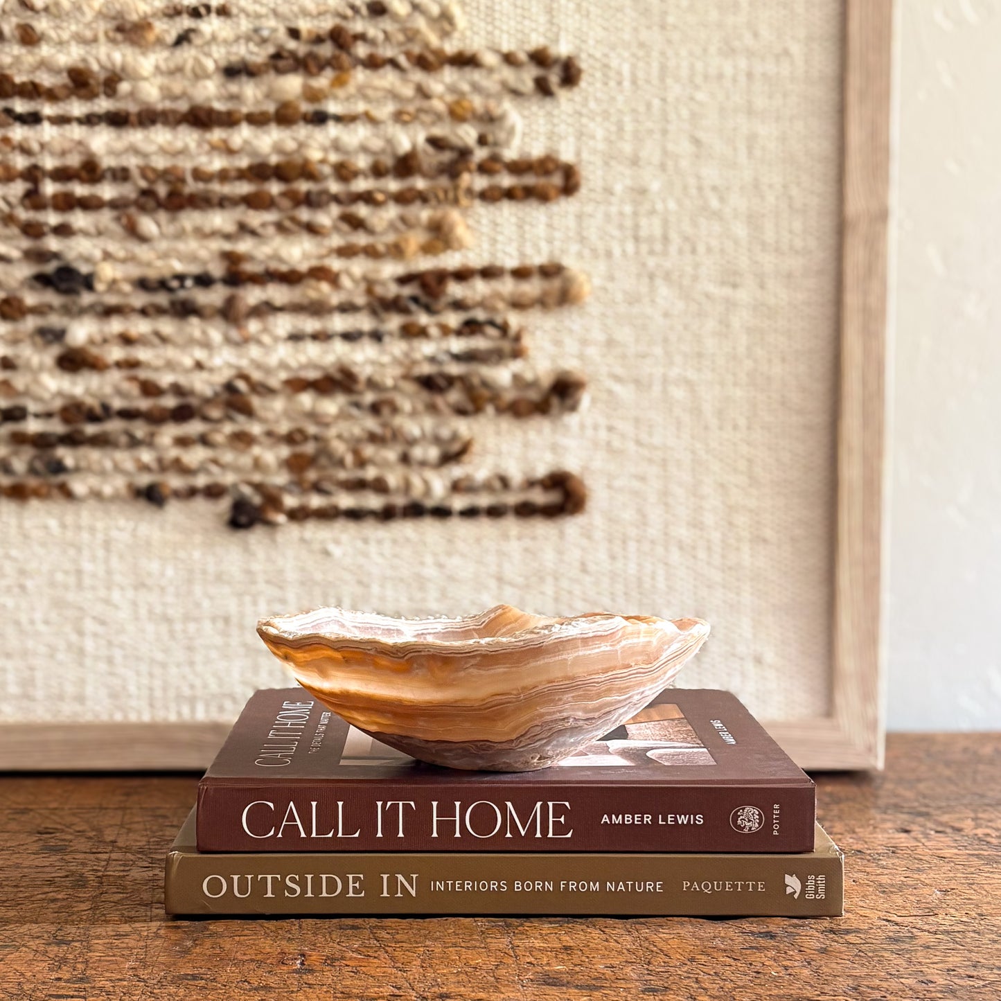 Amber onyx bowl with banded stone detail on books.