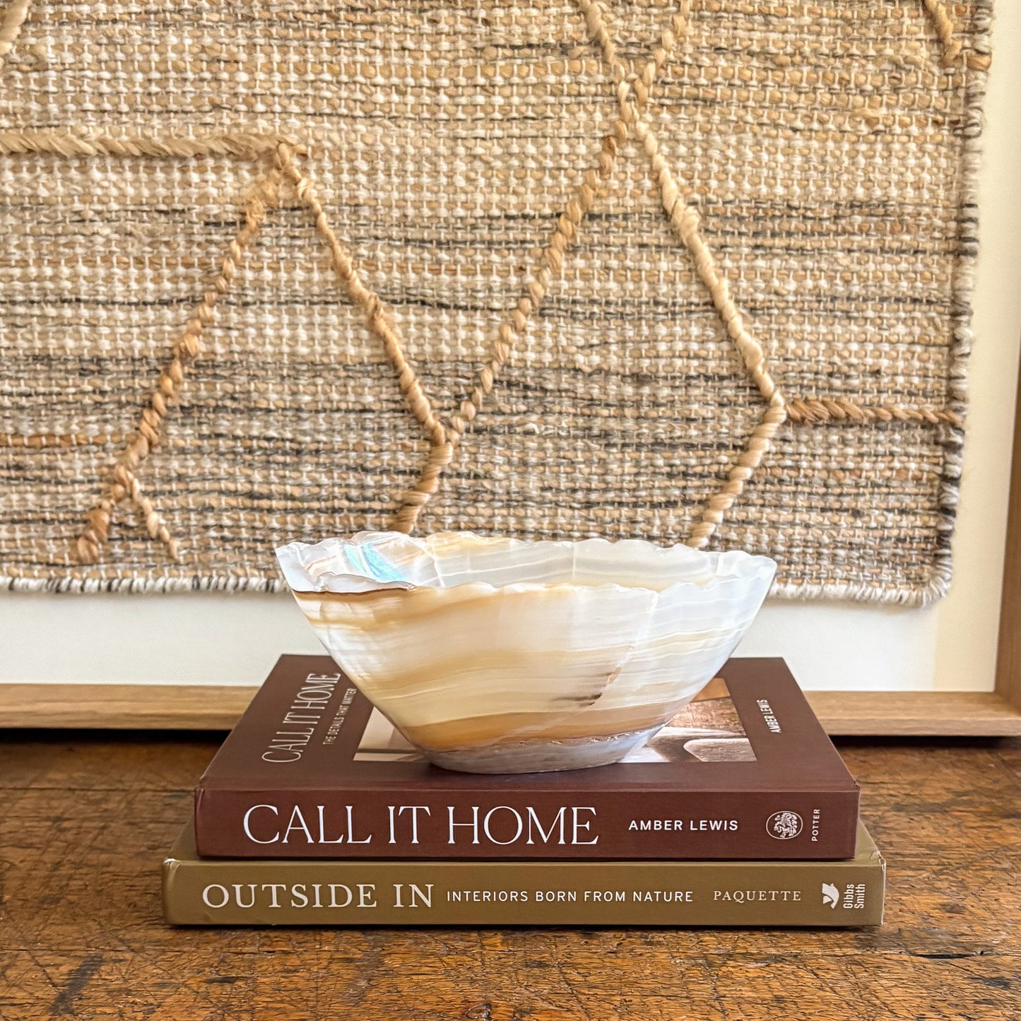 Decorative bowl on top of two books with a textured wall in the background