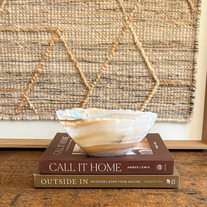Decorative bowl on top of two books with a textured wall in the background