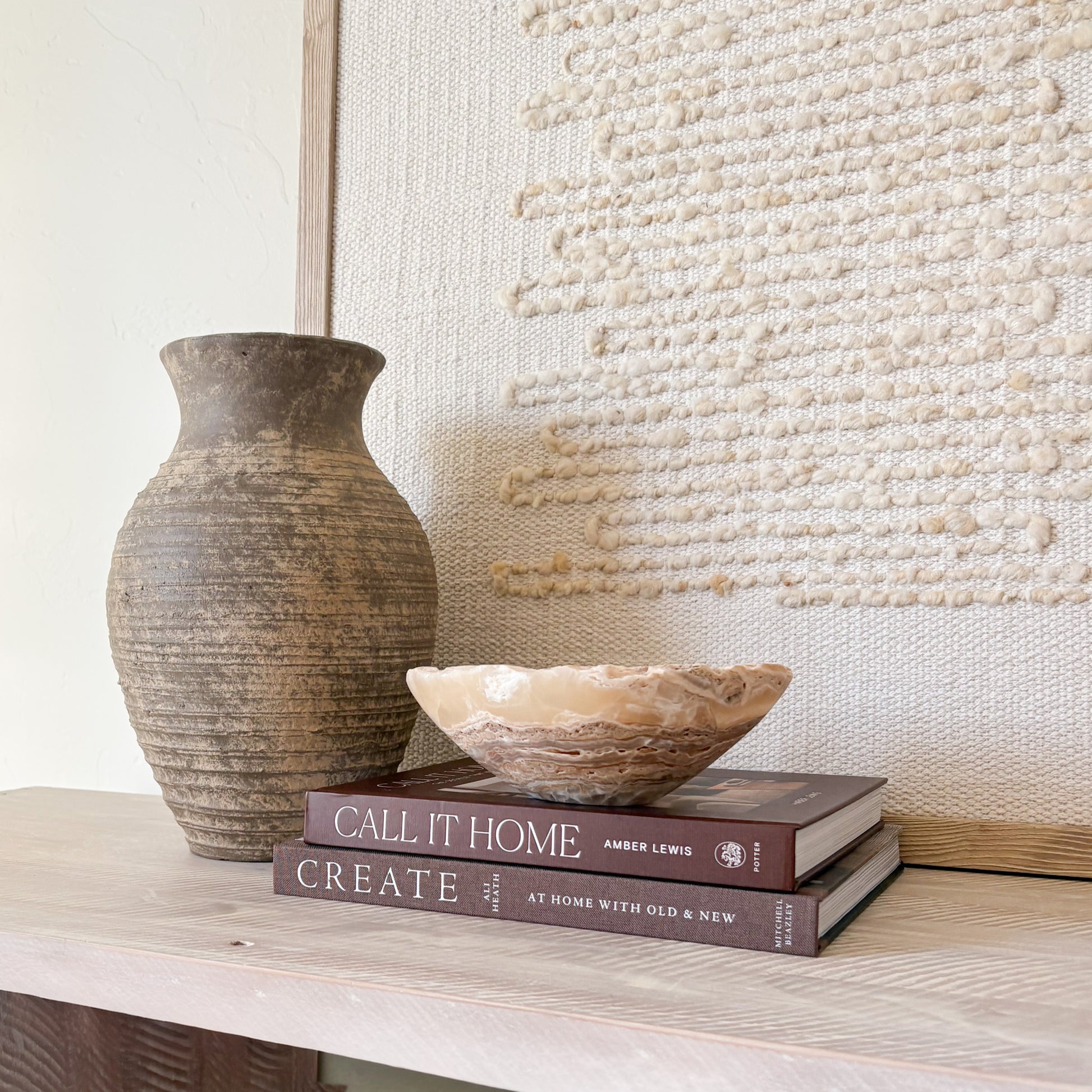 Small hand-carved amber onyx bowl resting on stacked books
