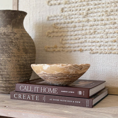 Small hand-carved amber onyx bowl made from natural stone, styled in neutral décor