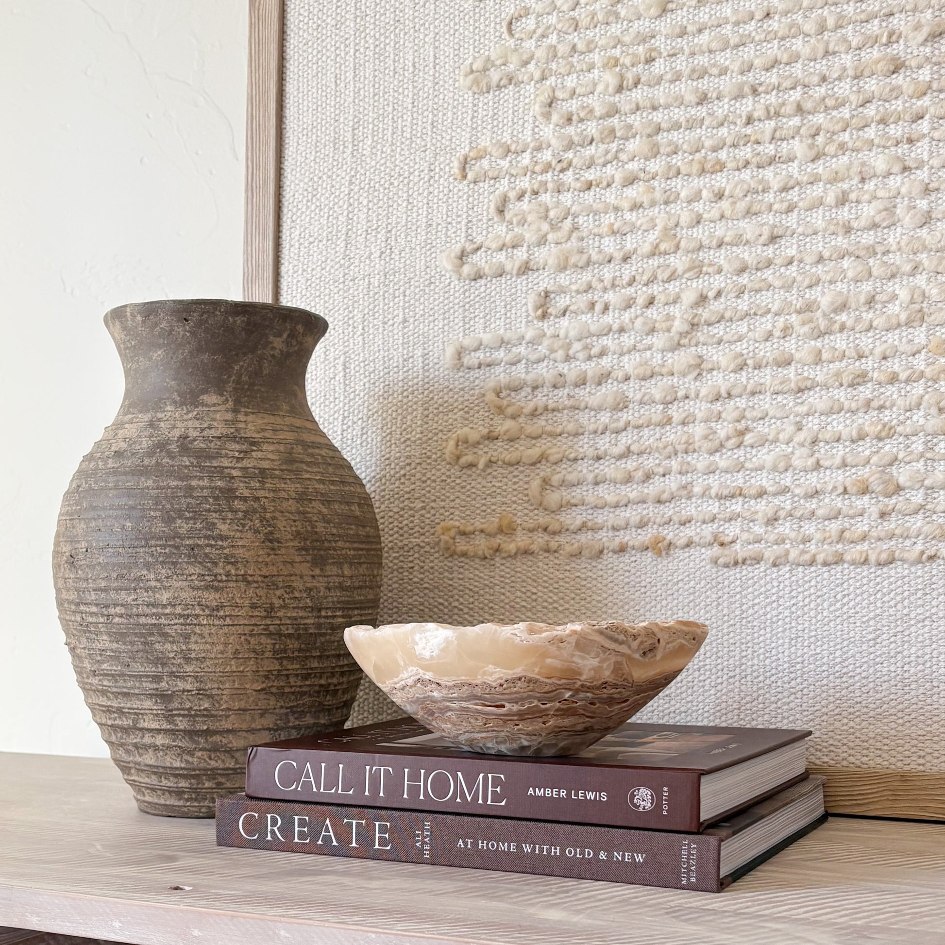 Decorative small hand-carved amber onyx bowl styled in a modern neutral interior