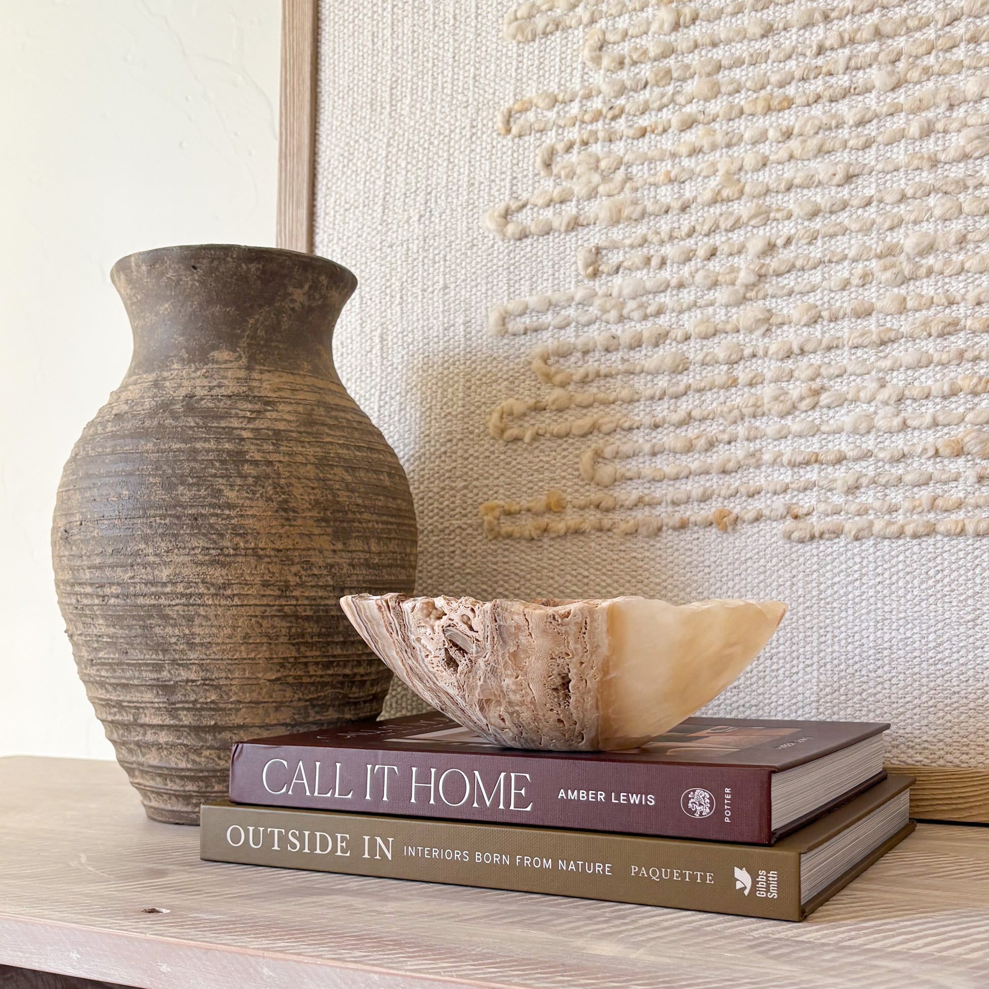 Decorative small hand-carved amber onyx bowl styled in a modern neutral interior