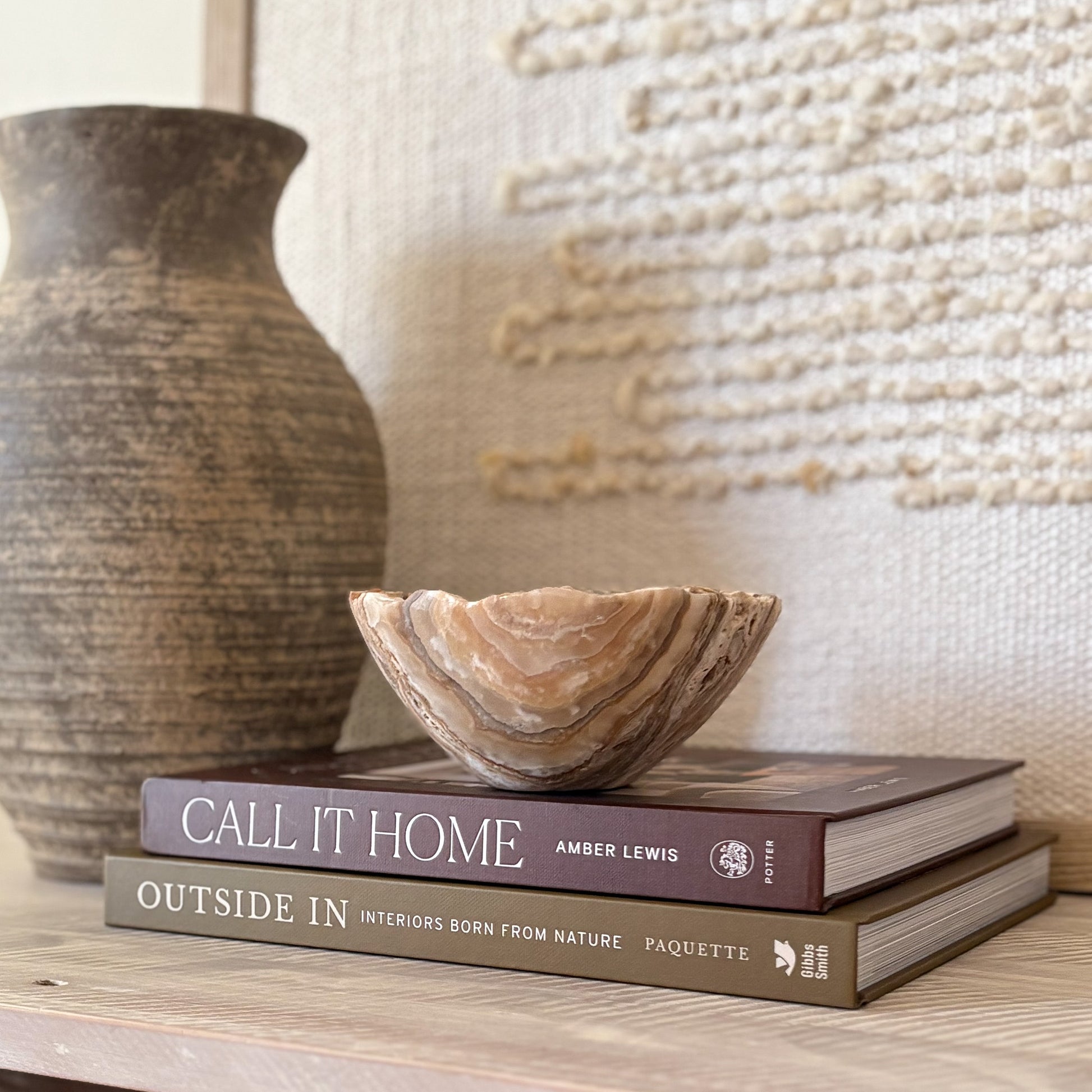 Small hand-carved amber onyx bowl with polished surface, warm honey hues, and natural stone patterns