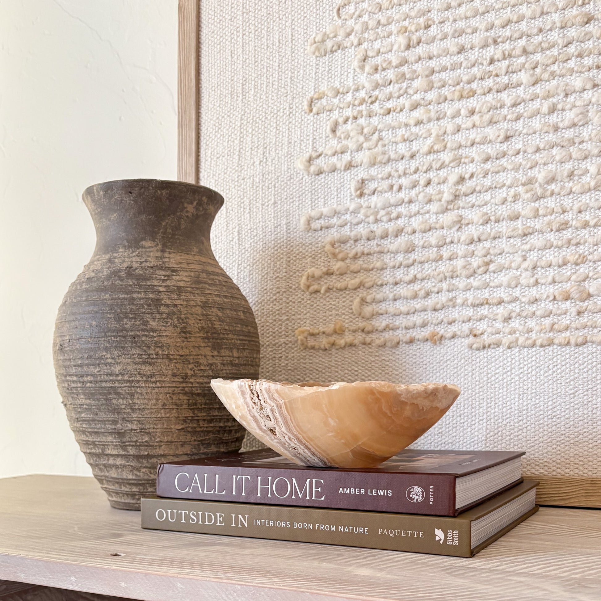 Decorative small hand-carved amber onyx bowl styled in a neutral modern interior
