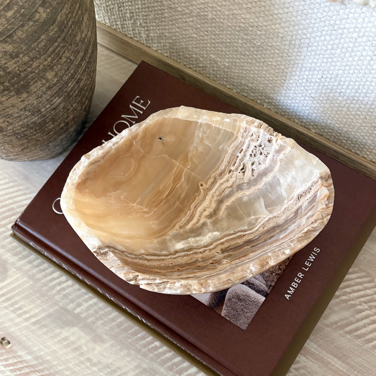 Decorative small hand-carved amber onyx bowl styled in a neutral modern interior