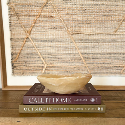 Small polished amber onyx bowl styled on coffee table books