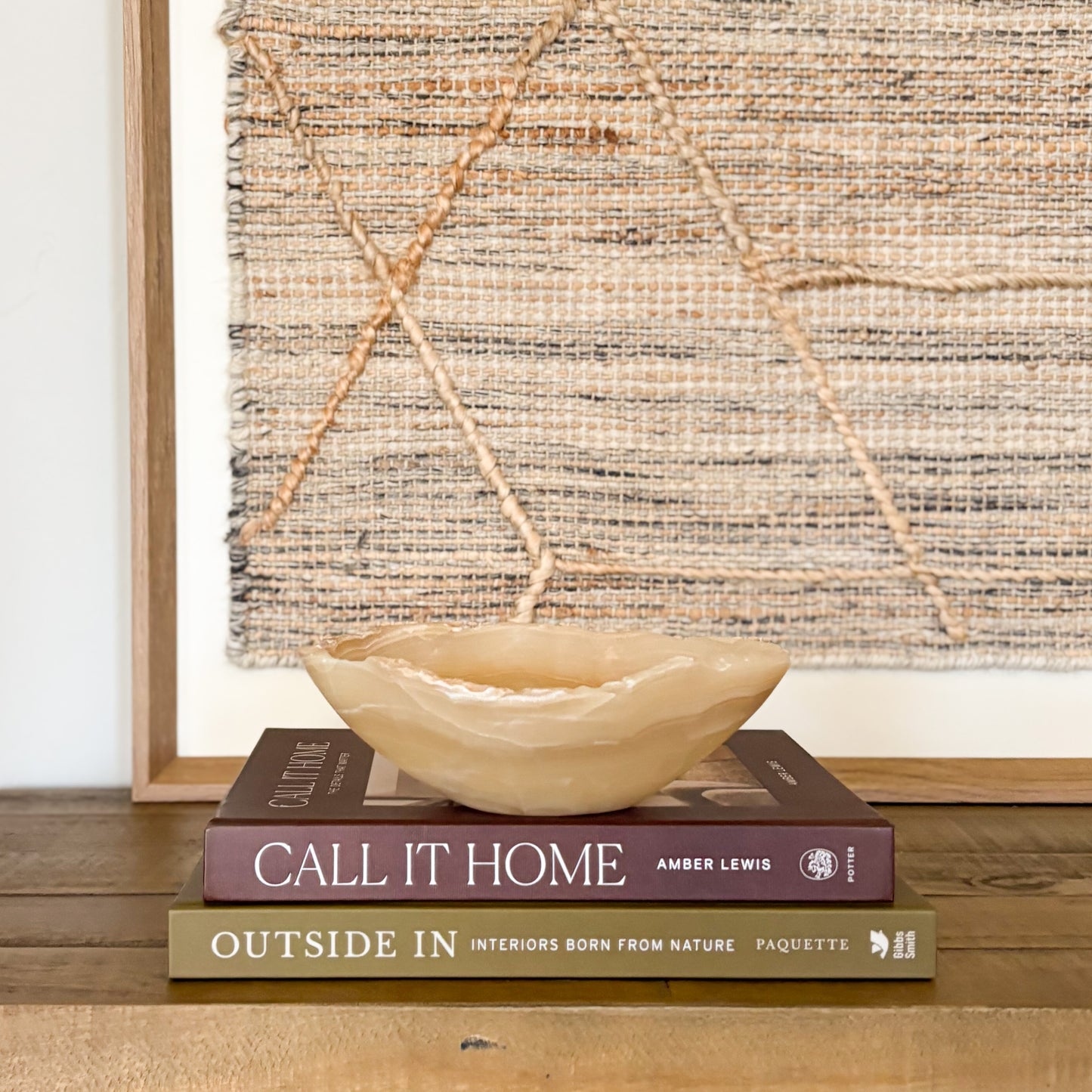 Small amber onyx bowl styled on wooden surface with neutral wall art