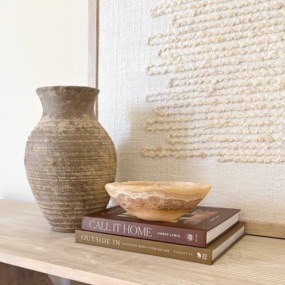 Hand-carved amber onyx bowl styled as luxury home decor on a modern tabletop