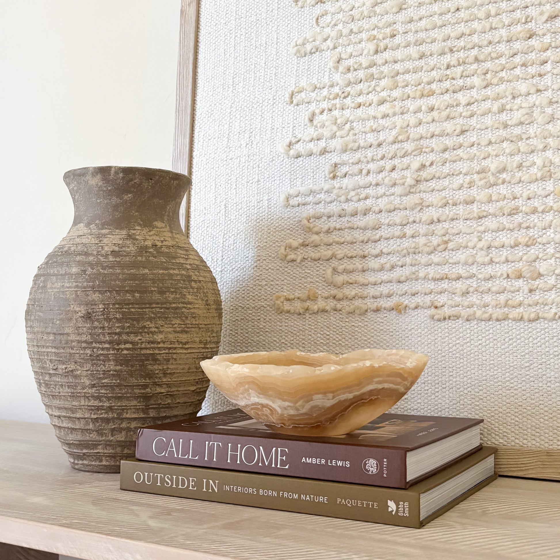 Hand-carved amber onyx bowl styled as luxury home decor on a modern tabletop