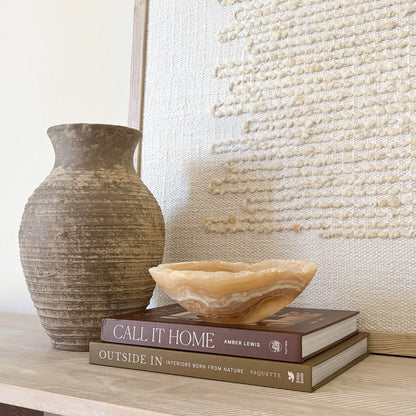 Hand-carved amber onyx bowl styled as luxury home decor on a modern tabletop