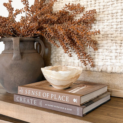 Hand carved amber onyx stone bowl with warm golden tones, artisan decor piece