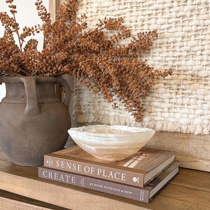 Artisan hand carved amber onyx bowl featuring unique natural stone patterns