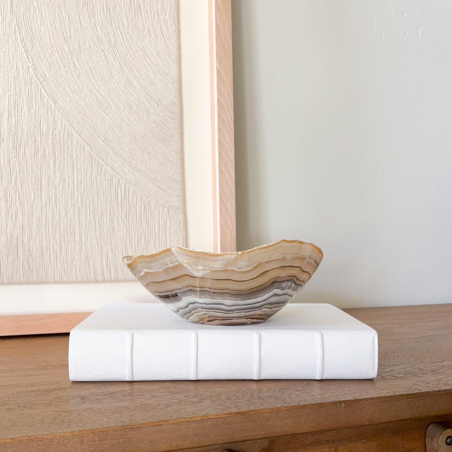 Hand carved amber onyx bowl featuring layered cream, gold, and gray banding, polished natural stone accent for modern home decor